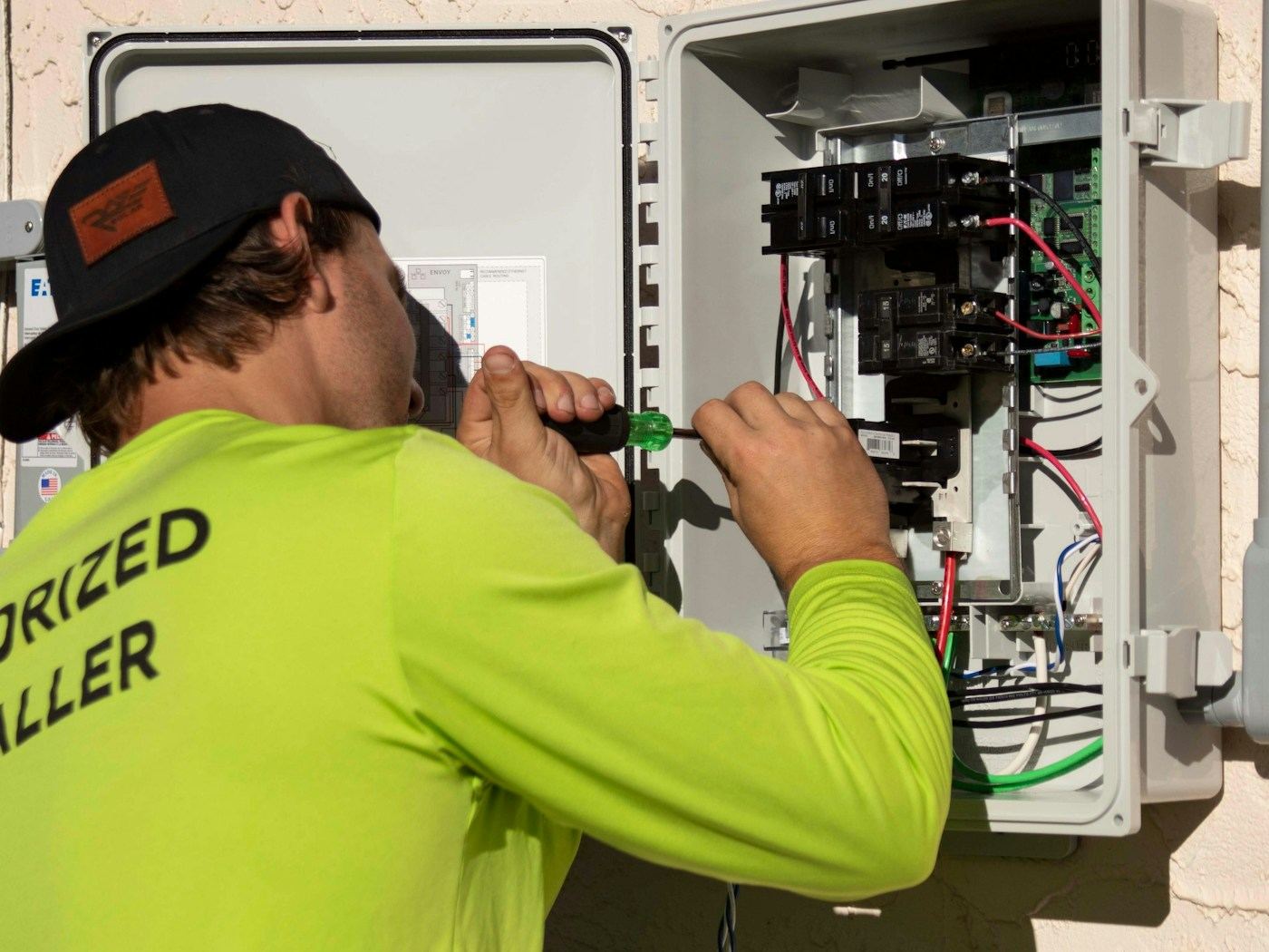 Electrician working inside an open electrical panel